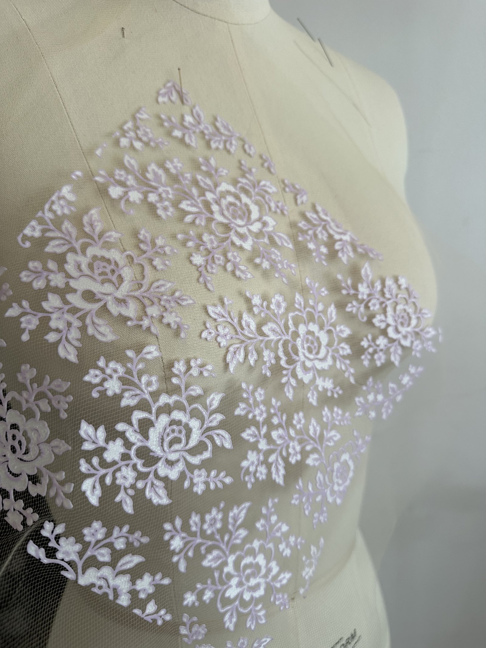 Lilac lace roses 3D printed onto sheer tulle, draped on a dress form